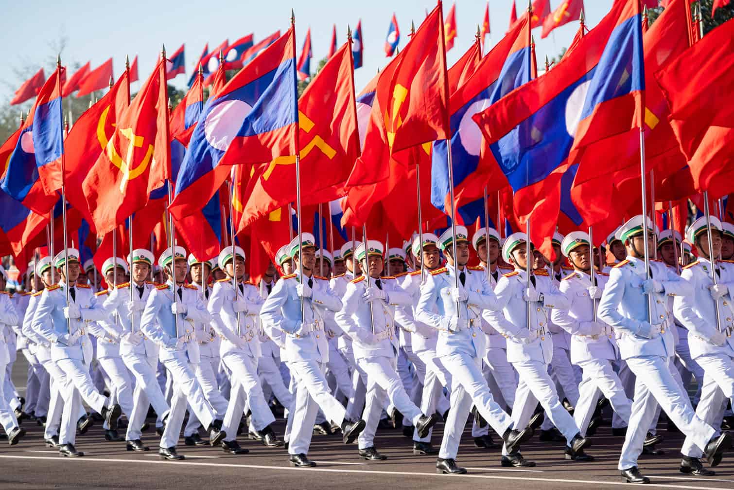 Laotian service members carry flags