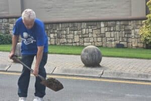 Ward 94 councillor David Foley fills dangerous potholes with sand as a temporary measure.