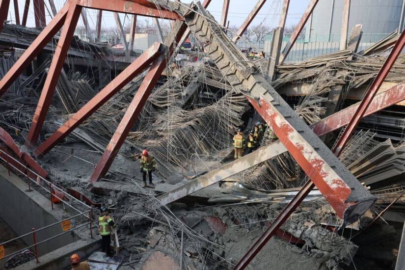 Rescuers work at the site of a collapsed building that was under construction