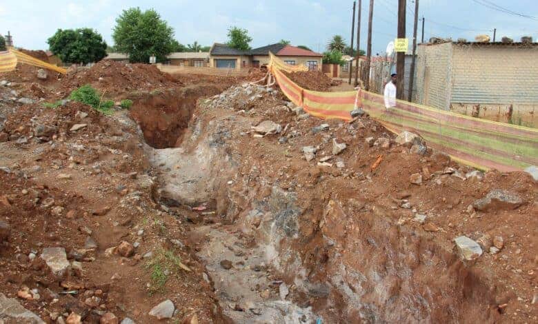 The huge unattended open trench near the old Teachers' Quarters, where a sinkhole caved in last night.