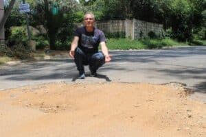 Ward 106 councillor Chris Santana shows the road surface deterioration on Gary Street, one of several roads repeatedly affected by pothole failures despite ongoing repair efforts.