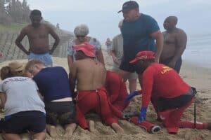 Beach emergency rescue scene with lifeguards and first responders helping at the coast.