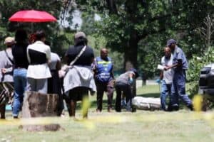 Family watches as Thomas Sithole's body is removed from the scene.