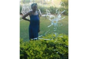 Kholofelo Kgomoeshwana looking at the bullet holes in her lounge window.