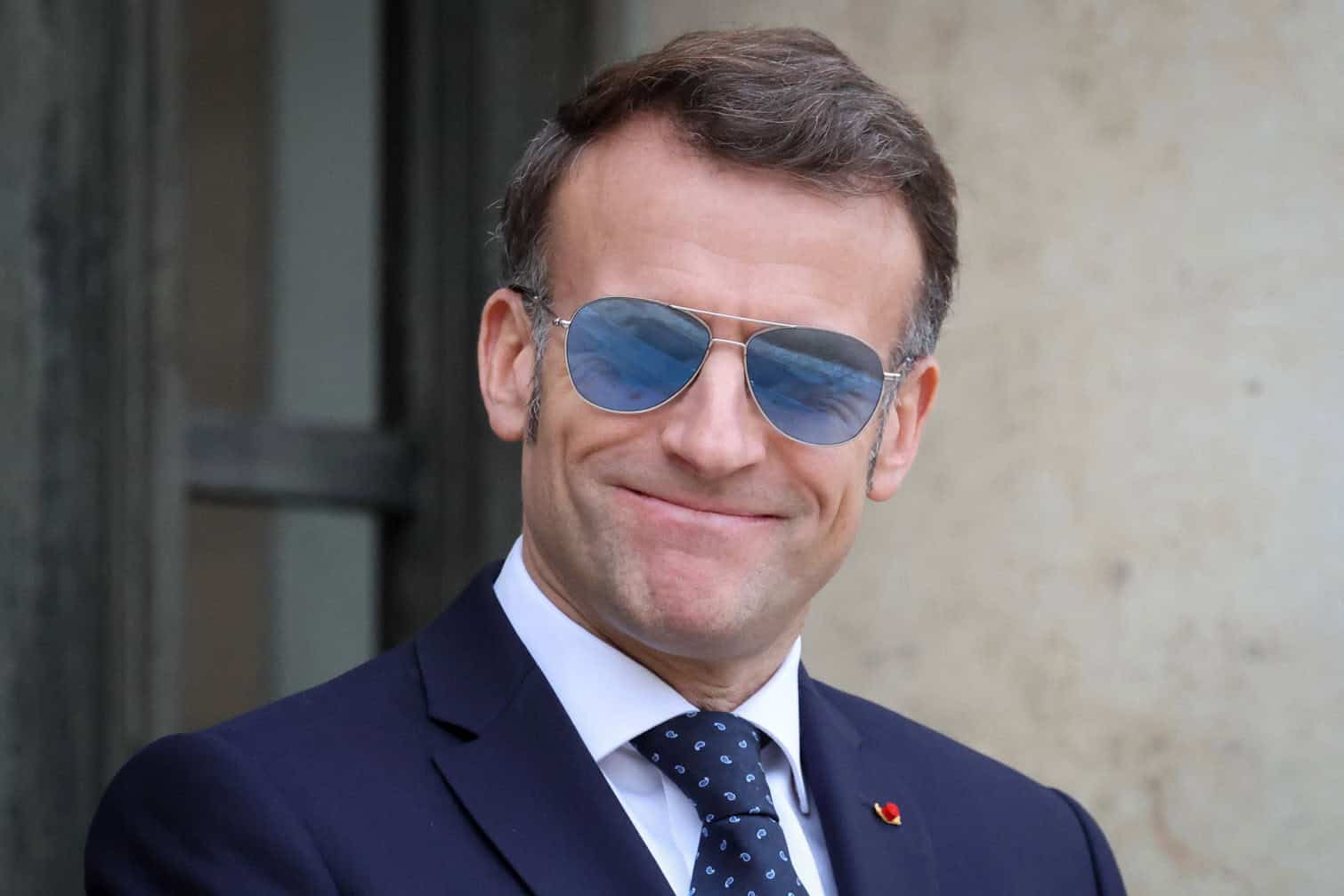 France's President Emmanuel Macron wearing a sunglasses