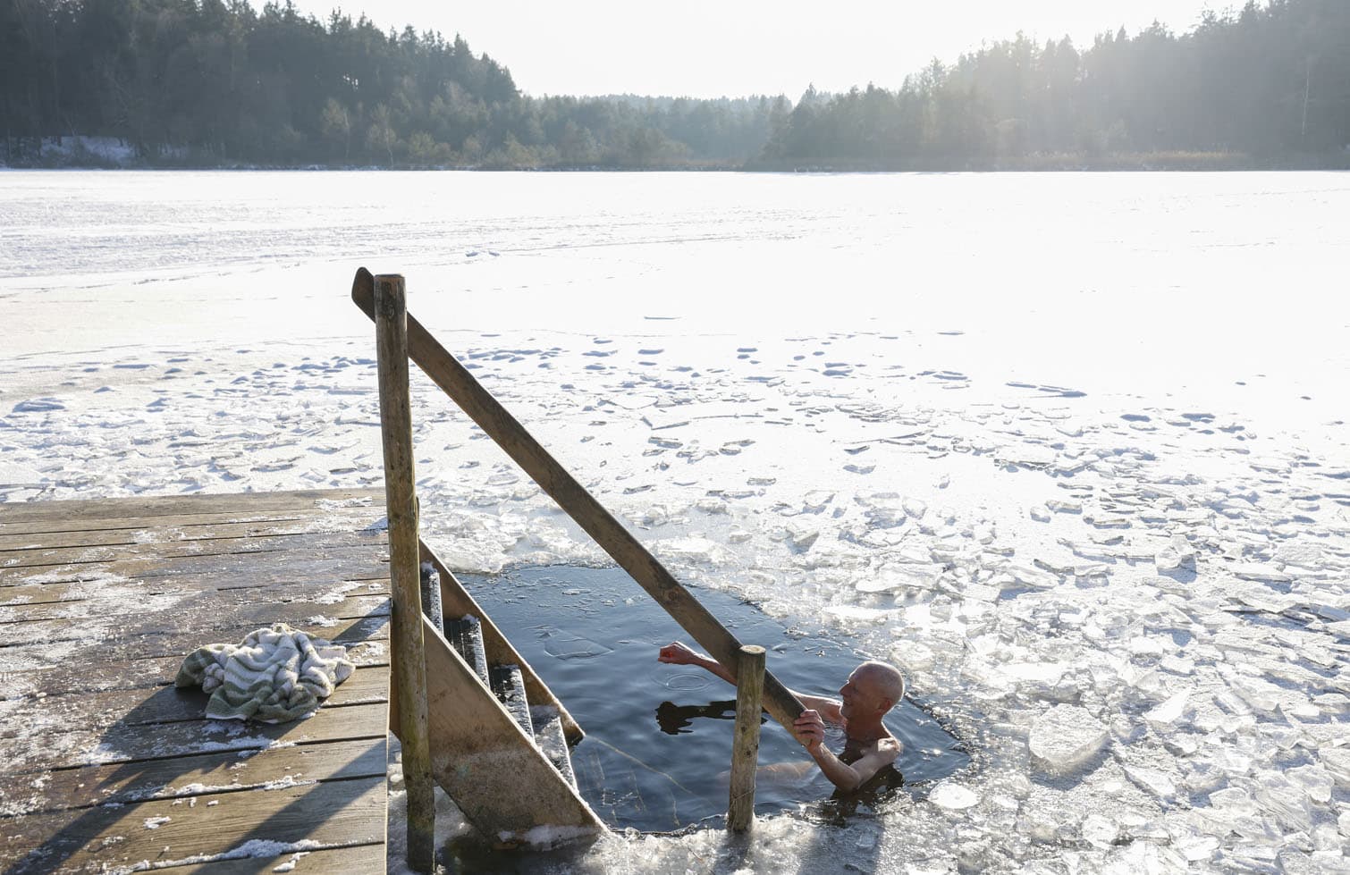 A man takes an ice bath in the frozen lake Griessee near Seeon