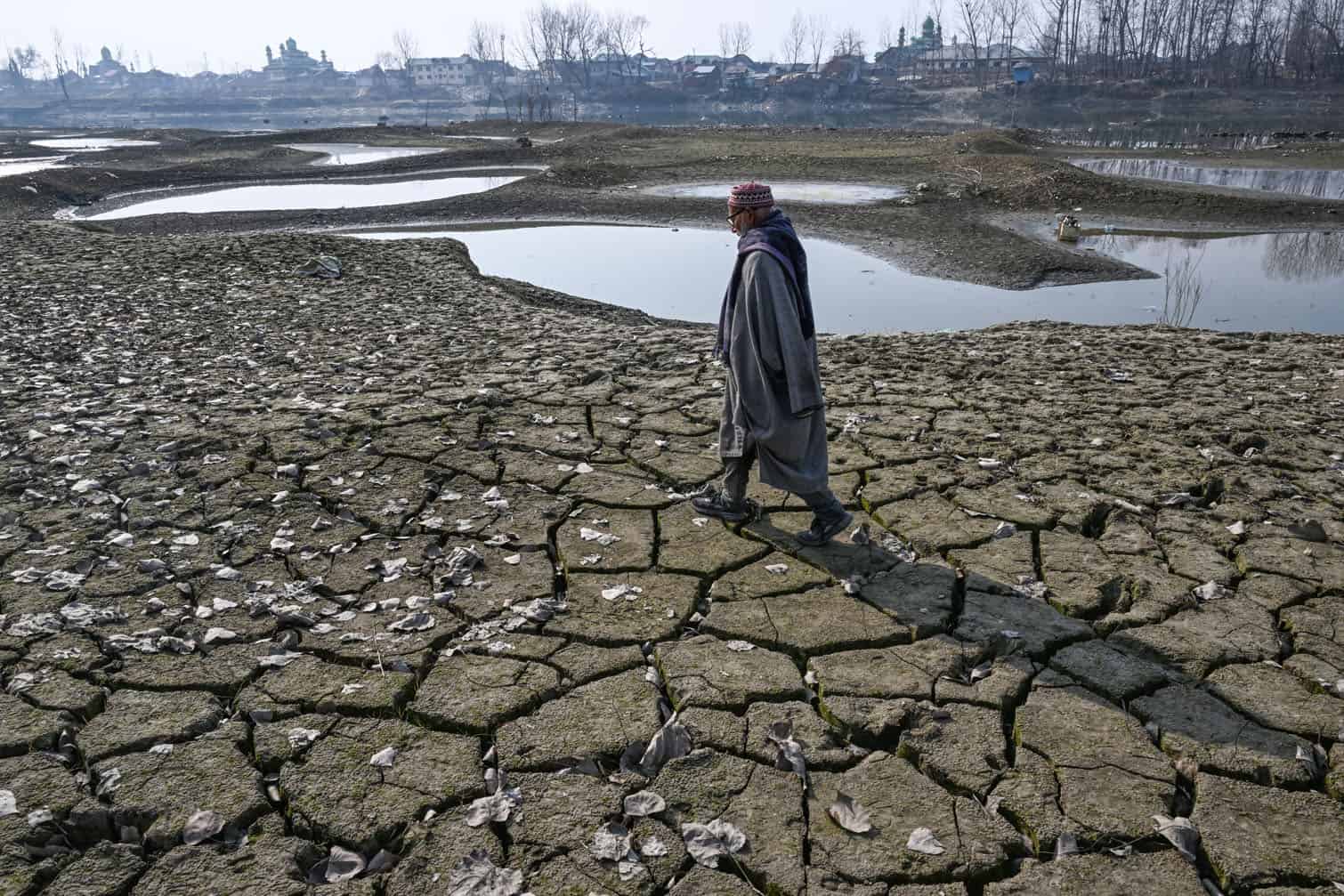 A man walks across Jhelum's parched riverbed