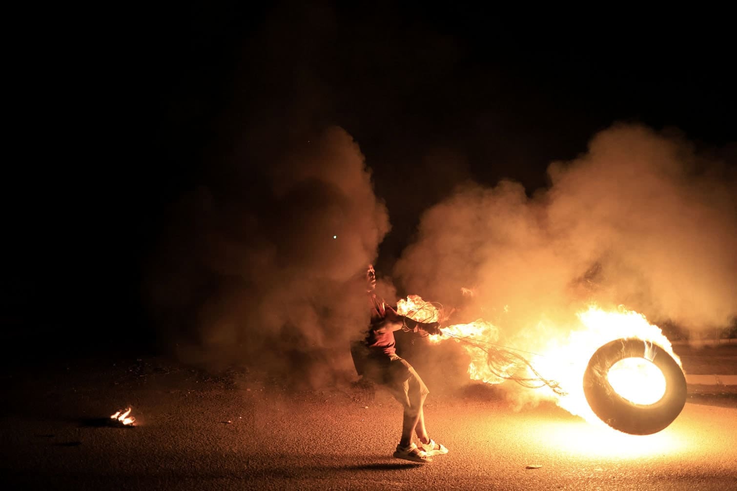 A young man swings a burning tyre in Zone 7 of Sebokeng township