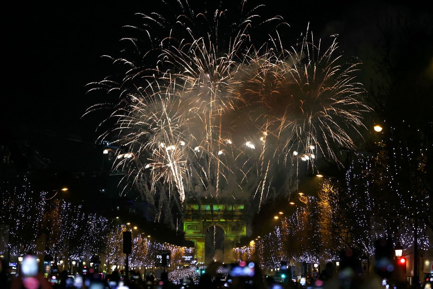 Fireworks explode in the sky over the Arc de Triomphe