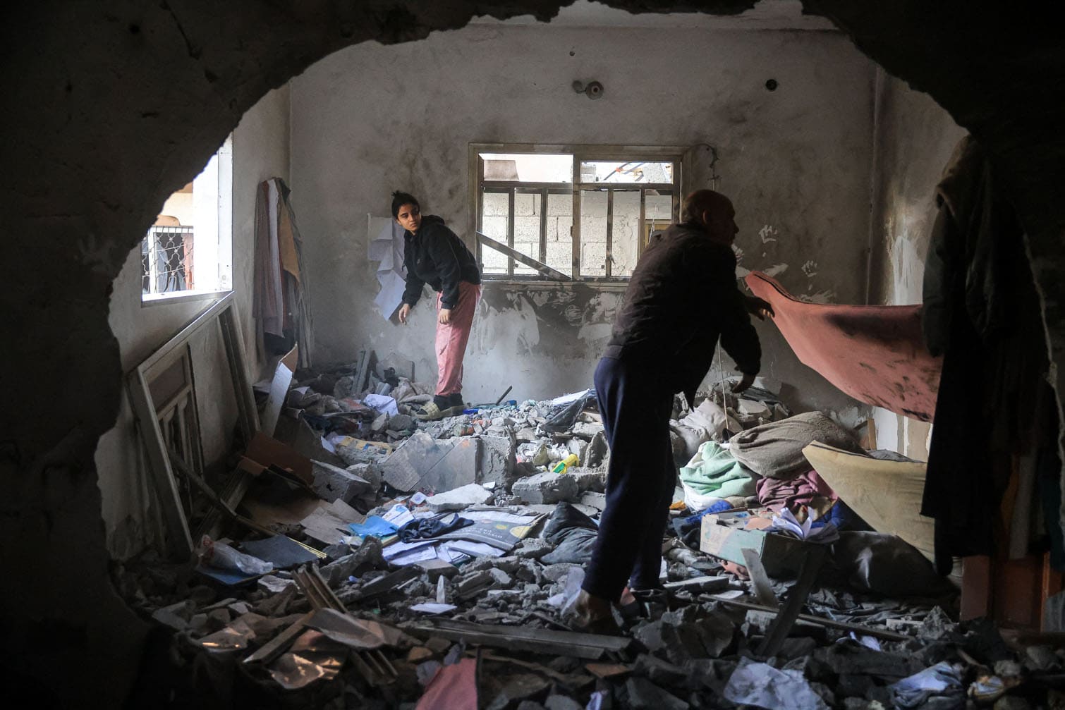 Palestinians salvage items from a house