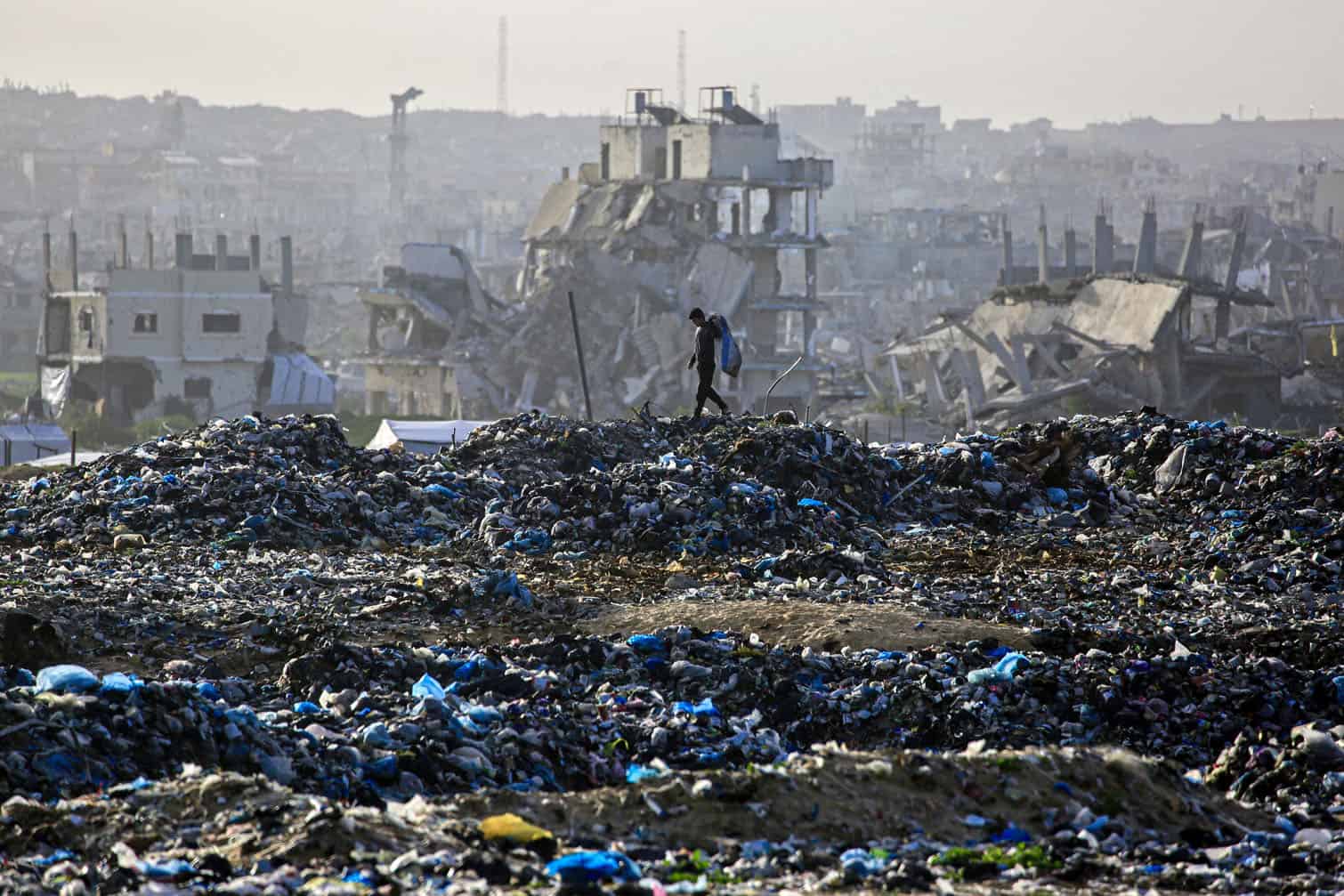 A Palestinian boy searches for recyclable material at a landfill