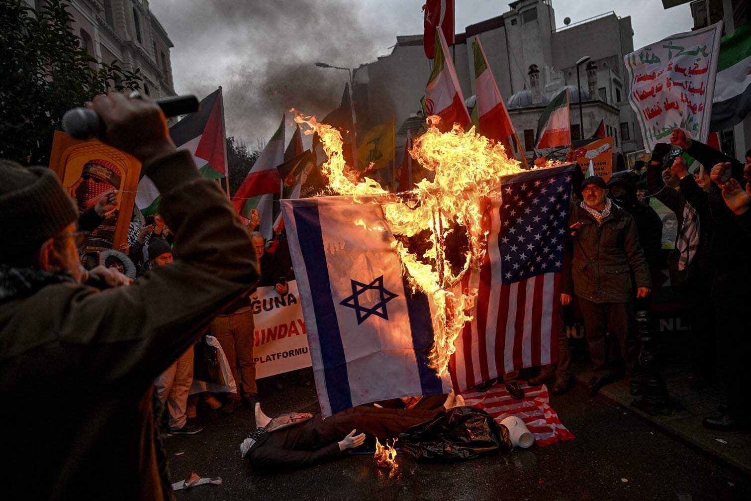 Protesters set fire to US and Israel national flags