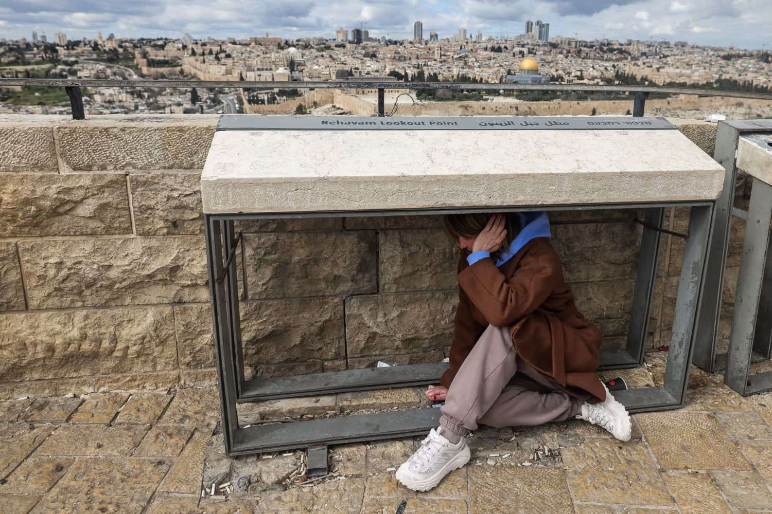 A person takes shelter as sirens sounded in Jerusalem on 28 February 2026, following the announcement that Israel had launched a pre-emptive strike on Iran. Israeli Prime Minister Benjamin Netanyahu said Iran must not be allowed to gain nuclear arms and urged Israelis to "stand together" after Israel and the United States launched strikes against the Islamic republic on 28 February. Picture: AHMAD GHARABLI / AFP