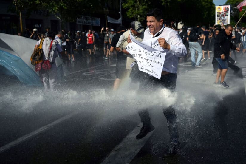 Demonstrators are sprayed with water