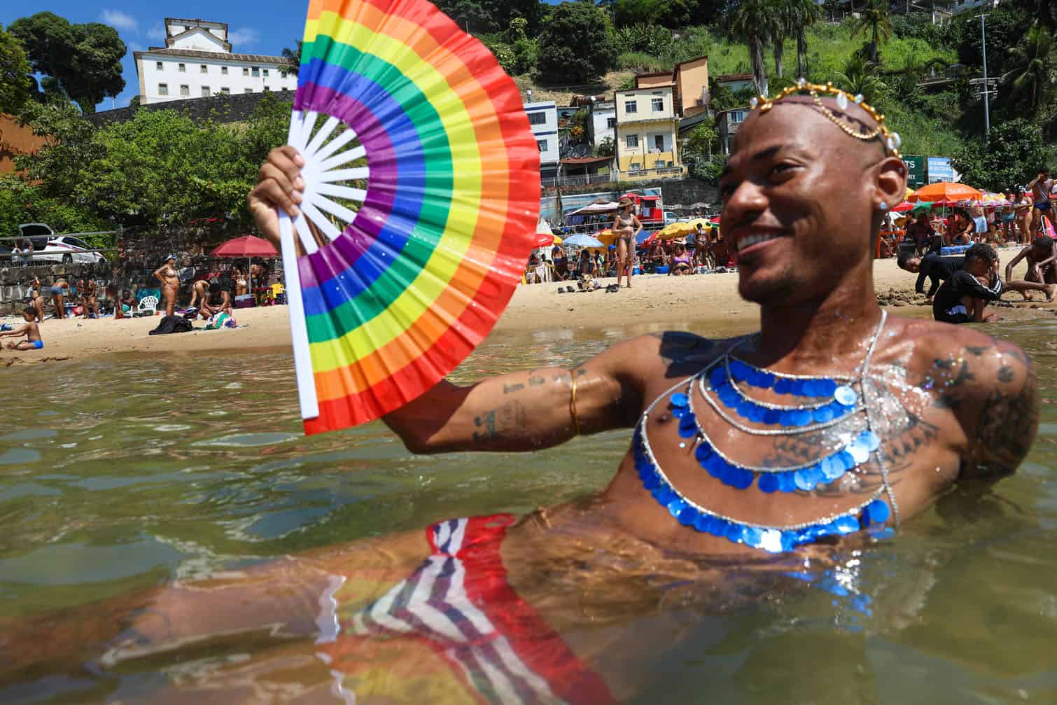 A reveler cools off in the sea during a carnival street group parade