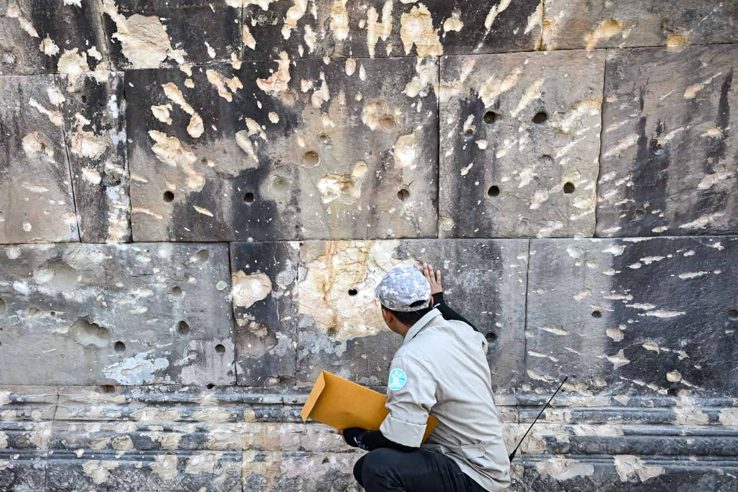 A conservator from the National Authority for Preah Vihear inspects a damaged wall