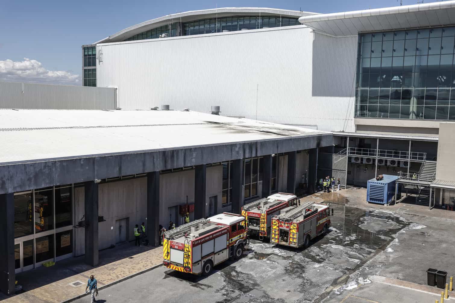 Emergency services vehicles are seen parked near the departure terminal