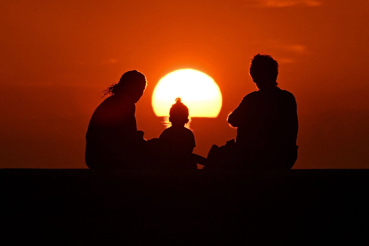 A family watches the sunset in Havana