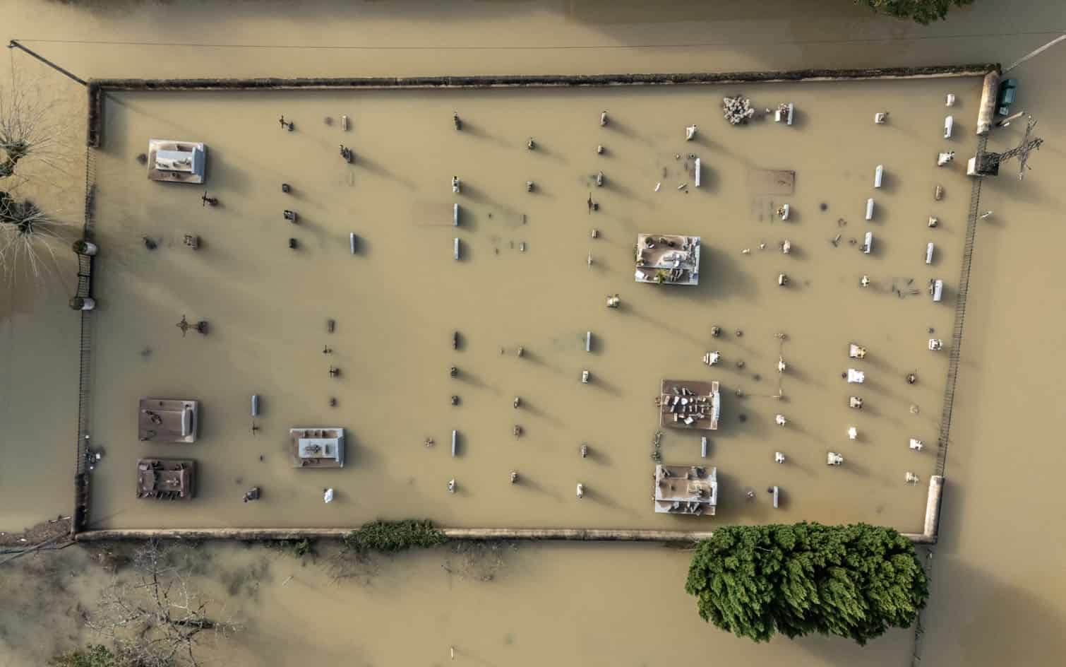 An aerial view shows floodwater surrounding a cemetery in Jusix
