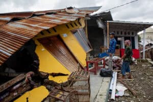 People salvage their belongings after land movement struck Padasari village