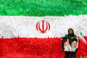 A woman poses with the pictures of Iran's late and current supreme leaders