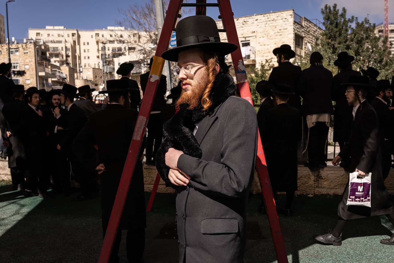 Ultra-Orthodox Jewish men gather outside a military recruitment centre