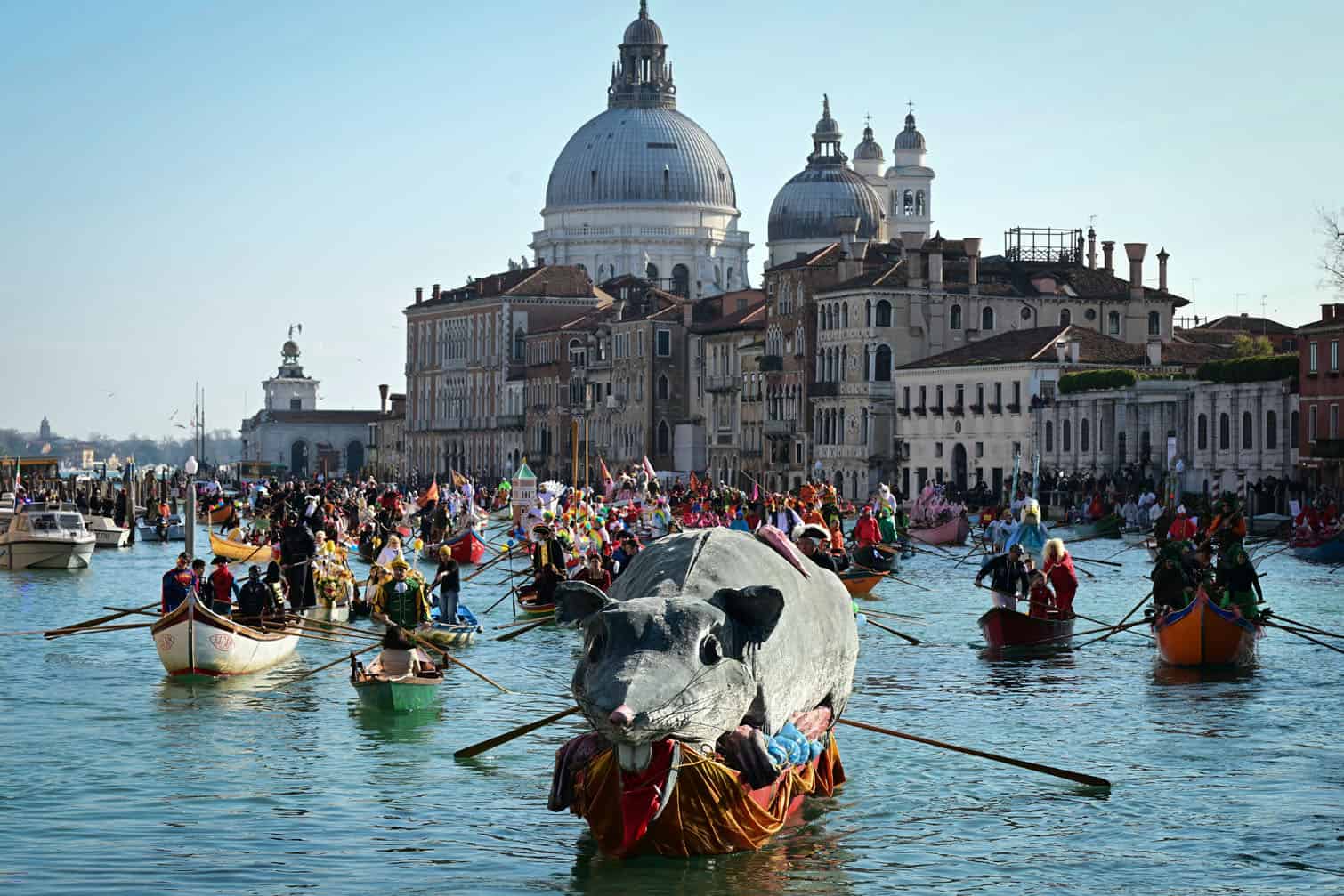 Dressed up revellers sail their decorated boats on the Grand Canal