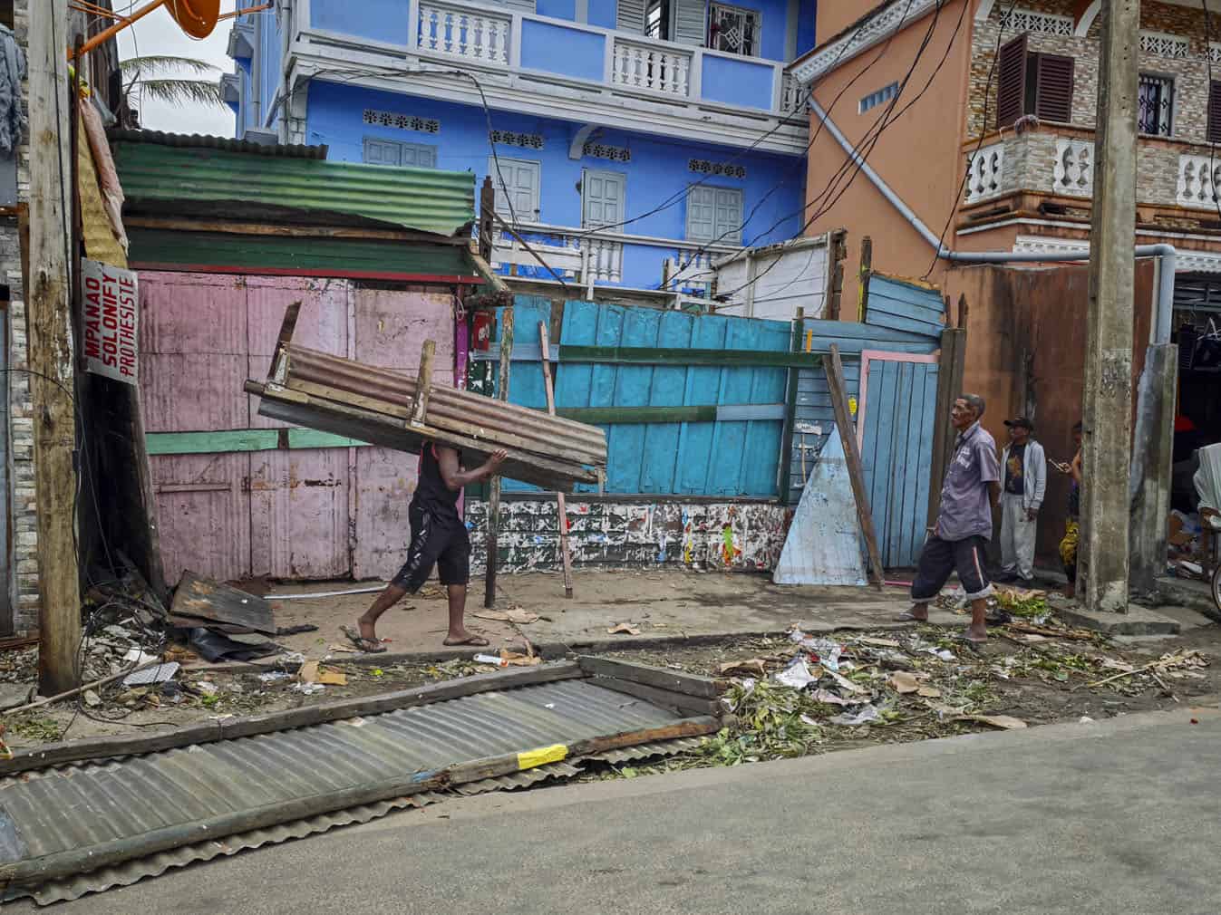 A resident carries items he salvaged in the city of Toamasina