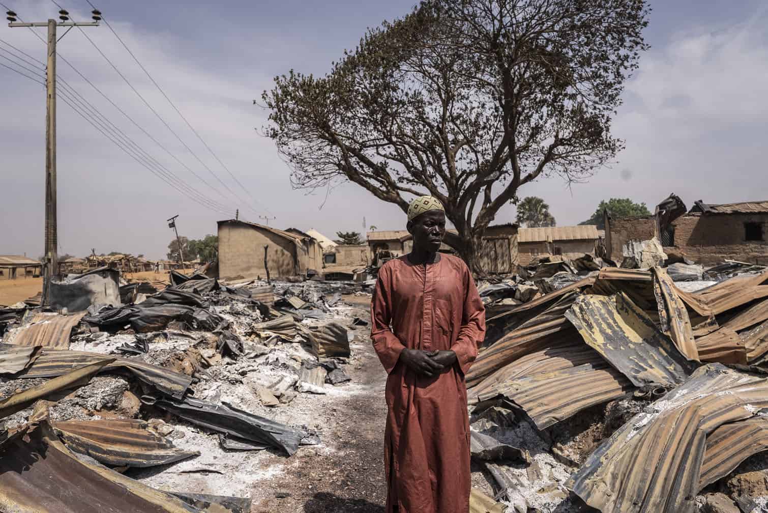 A resident stands among burnt debris in Nigeria