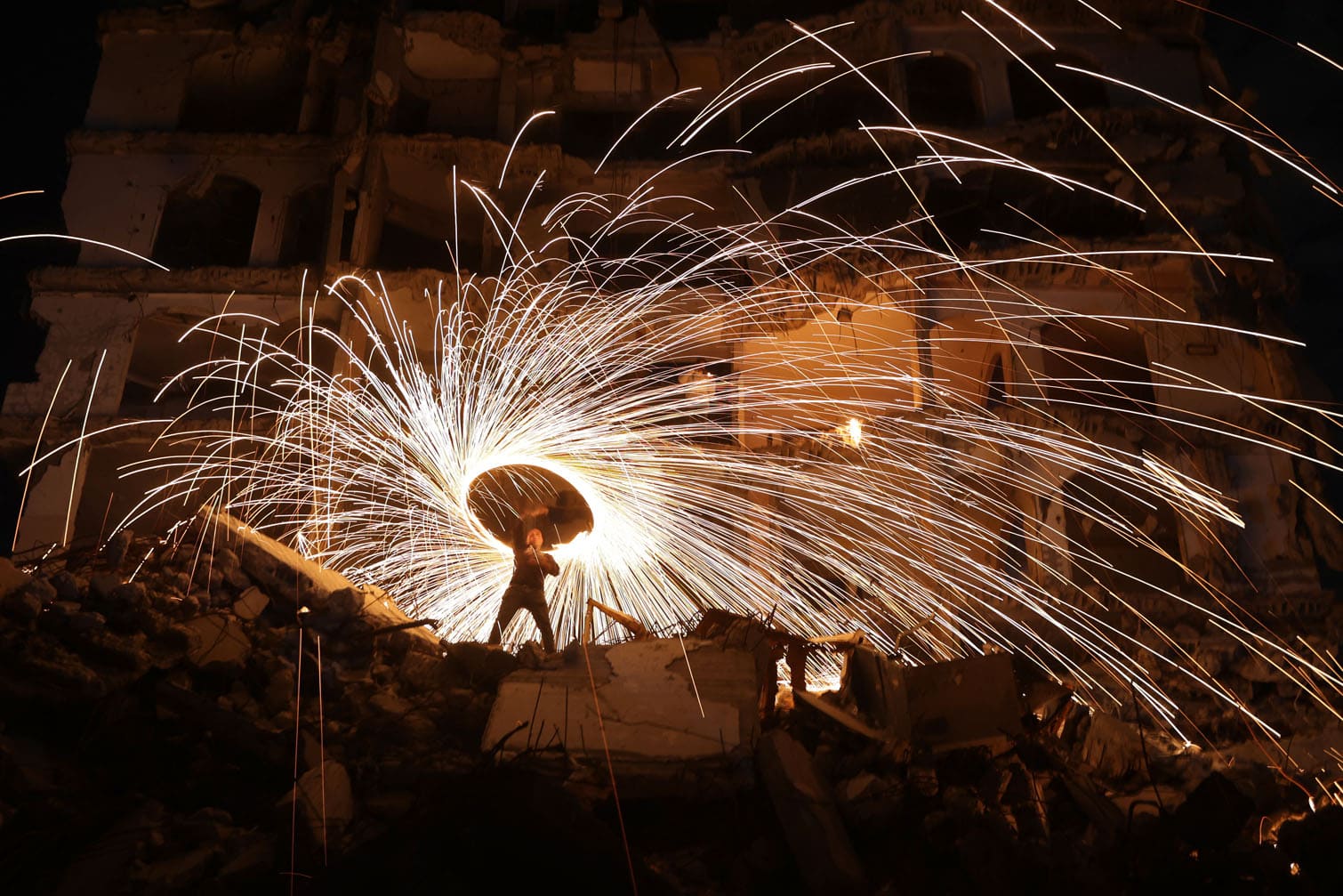 A displaced Palestinian plays with fireworks