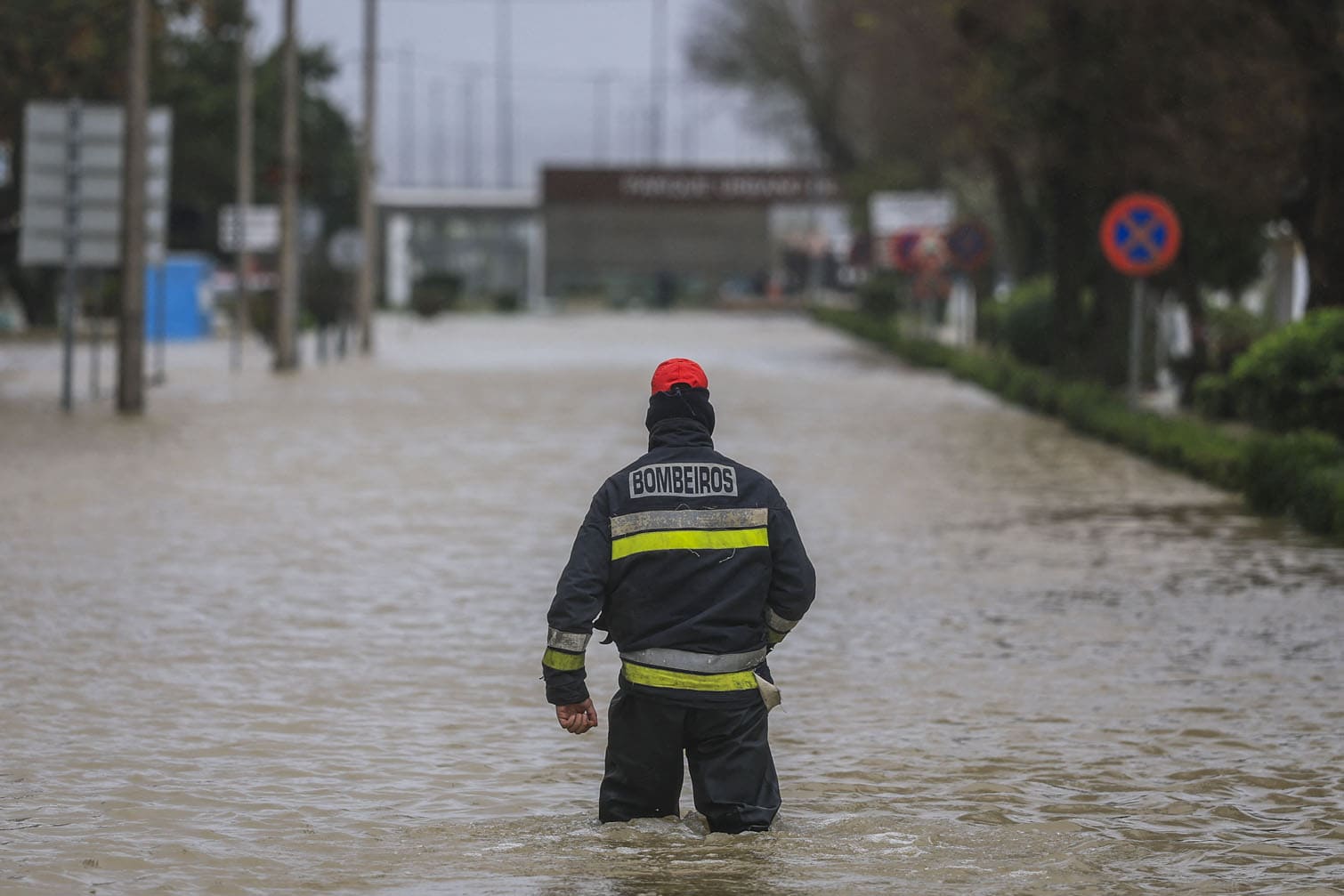 A firefighter walks in a flooded street