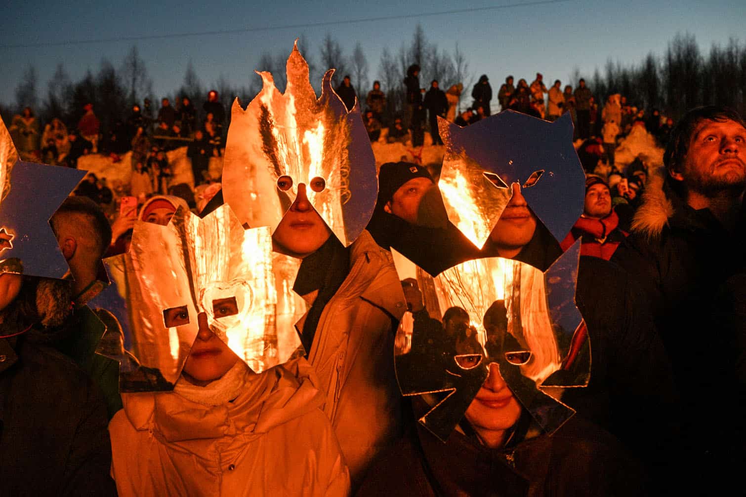Spectators wearing costumes watch the burning of the 'Burning Heart"