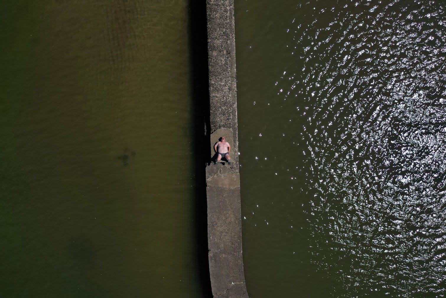 a man sunbathes on a breakwater at Playa Ramirez beach