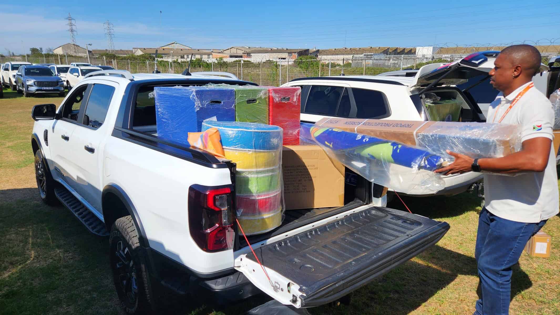 Man loading learnng materials onto a bakkie