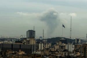 A plume of smoke rises from the site of a strike in Tehran on March 16, 2026.