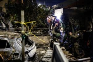 Israeli security forces and emergency personnel gather at the site of a strike
