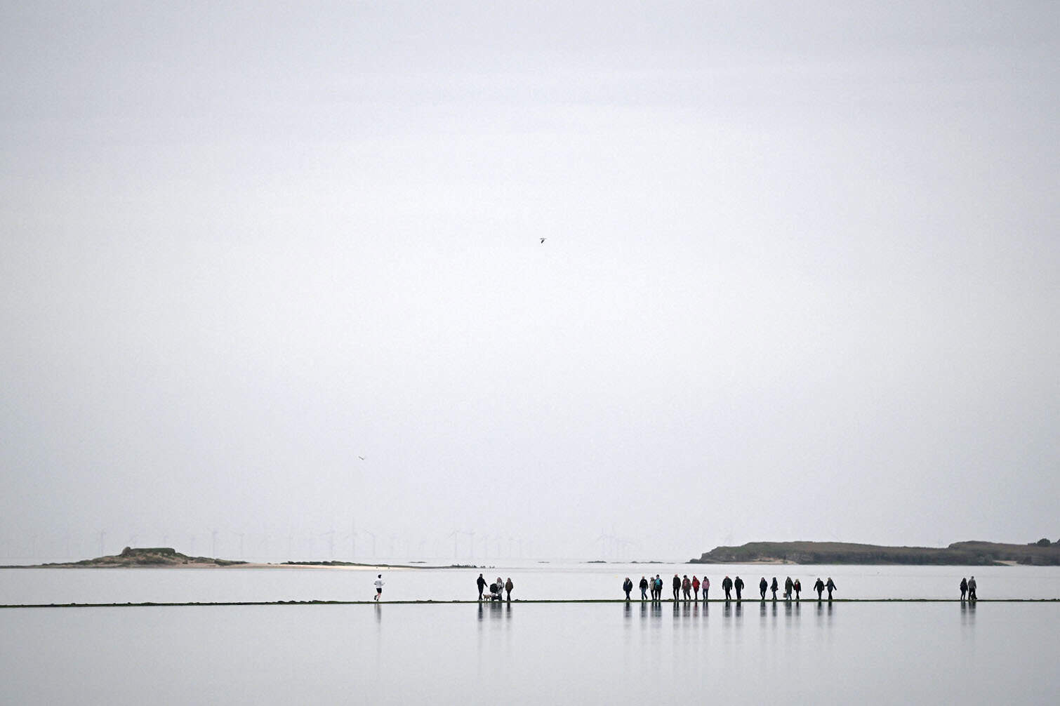 People walk around the Marine Lake at West Kirkby
