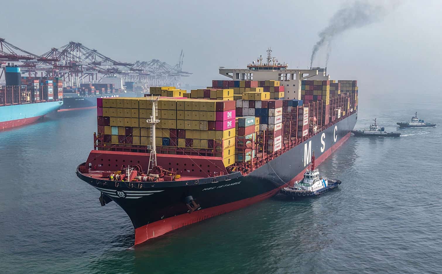 A cargo ship is moved to a berth at the container terminal