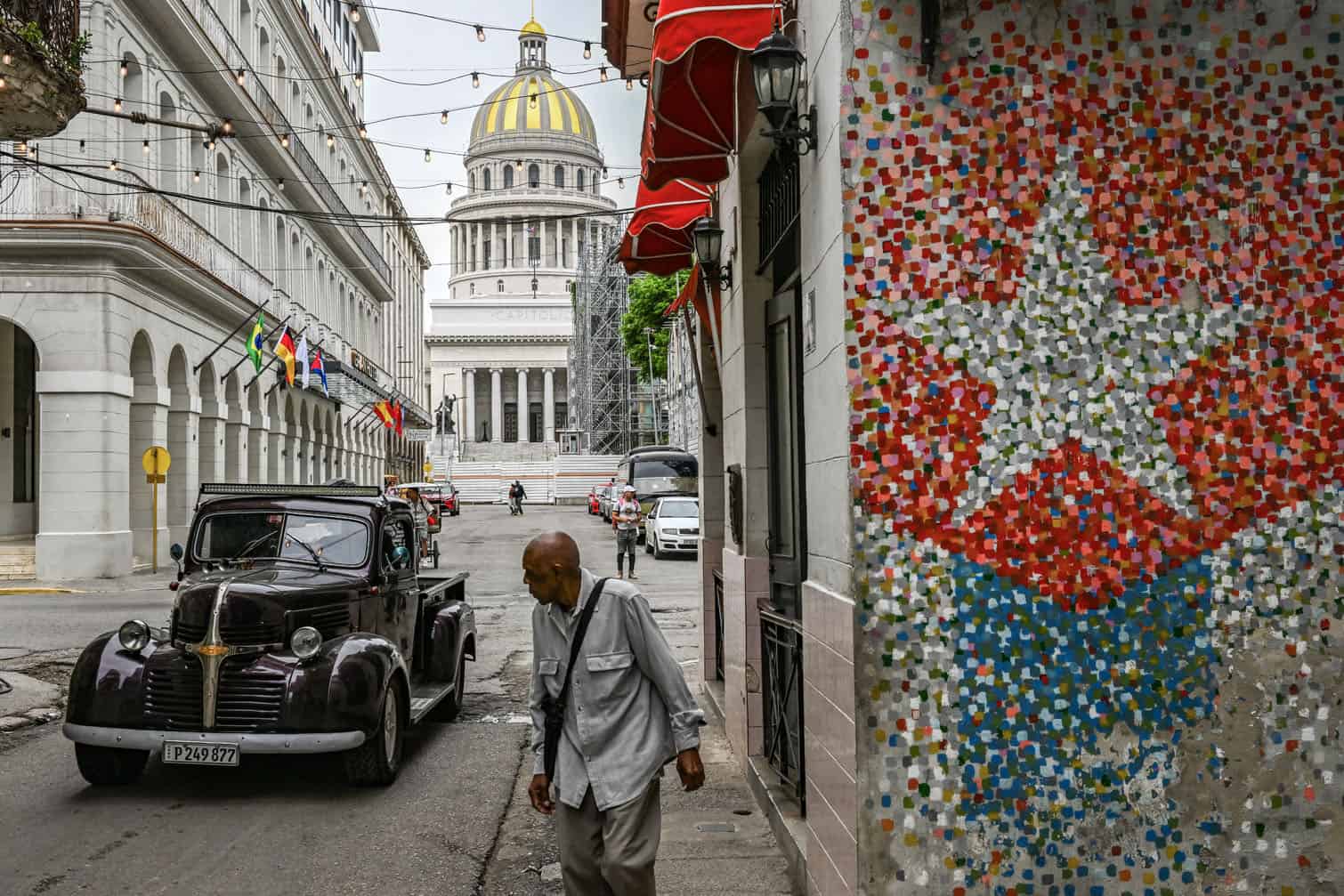 An elderly man walks in a street in Havana