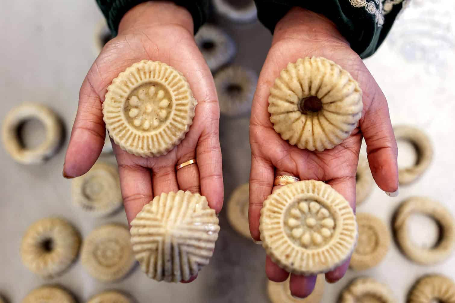 A woman holds in her hands freshly-prepared biscuits