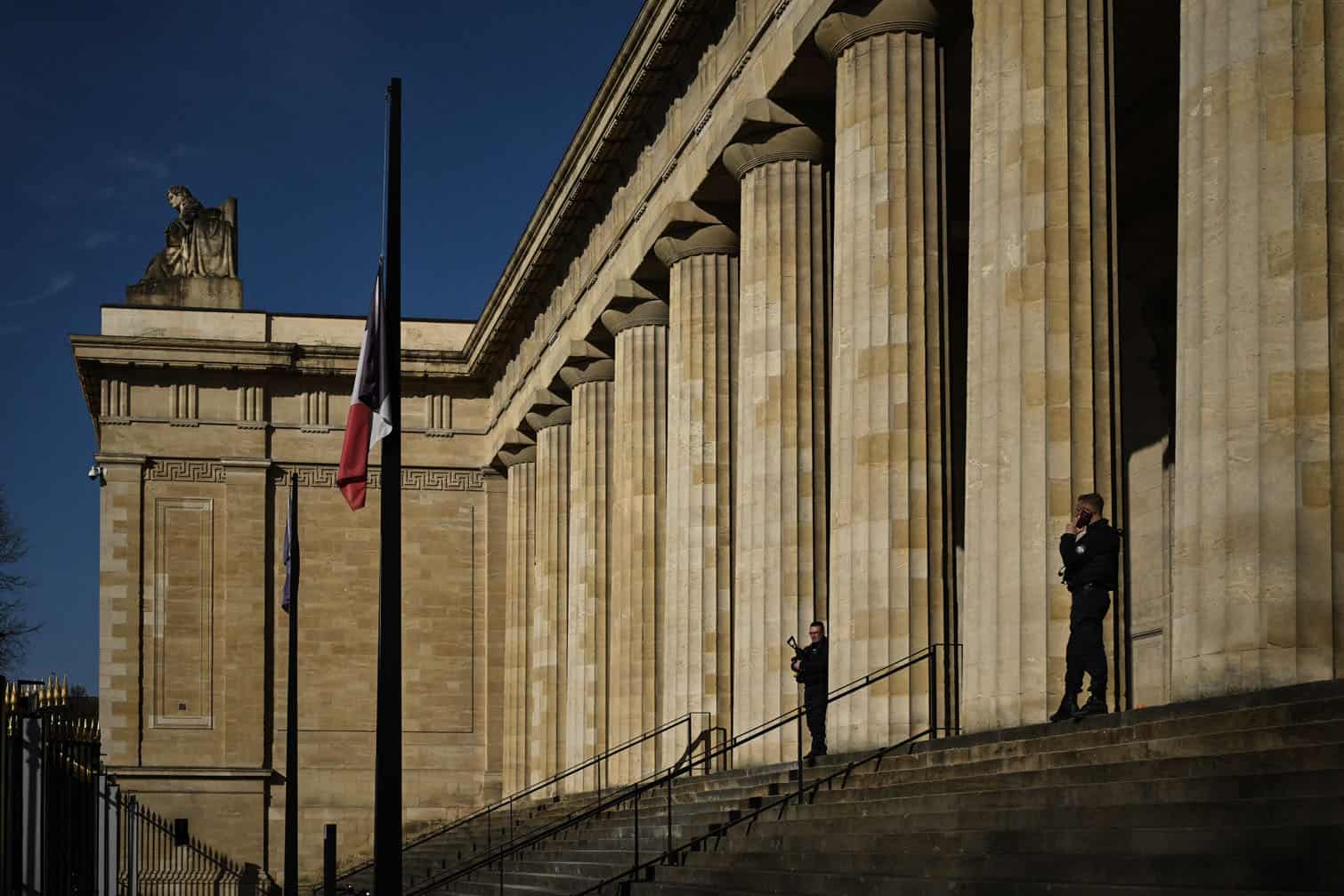 A police officer stands on the steps of the courthouse in Bordeaux