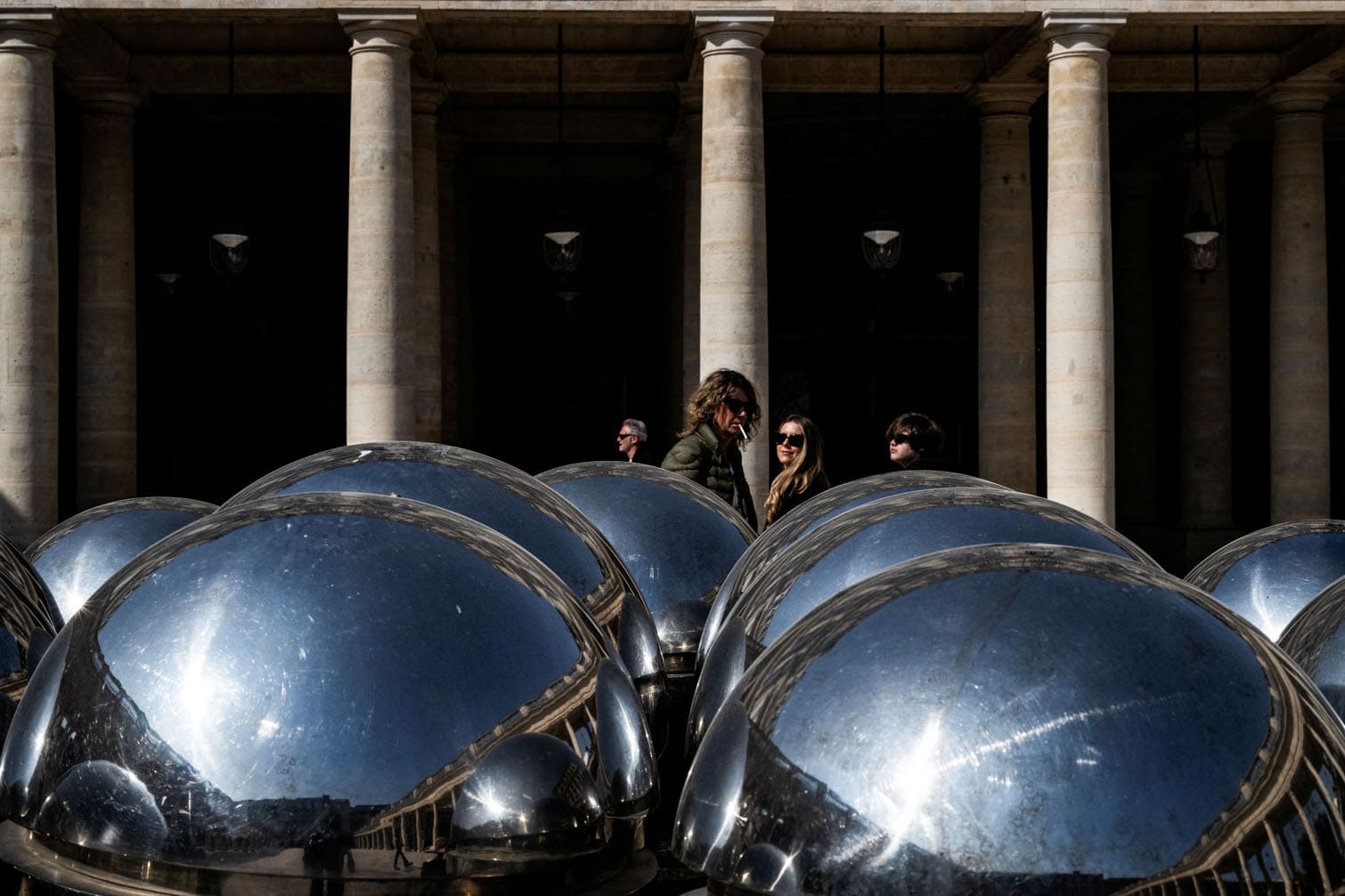 Pedestrians walk past the "Spherades"