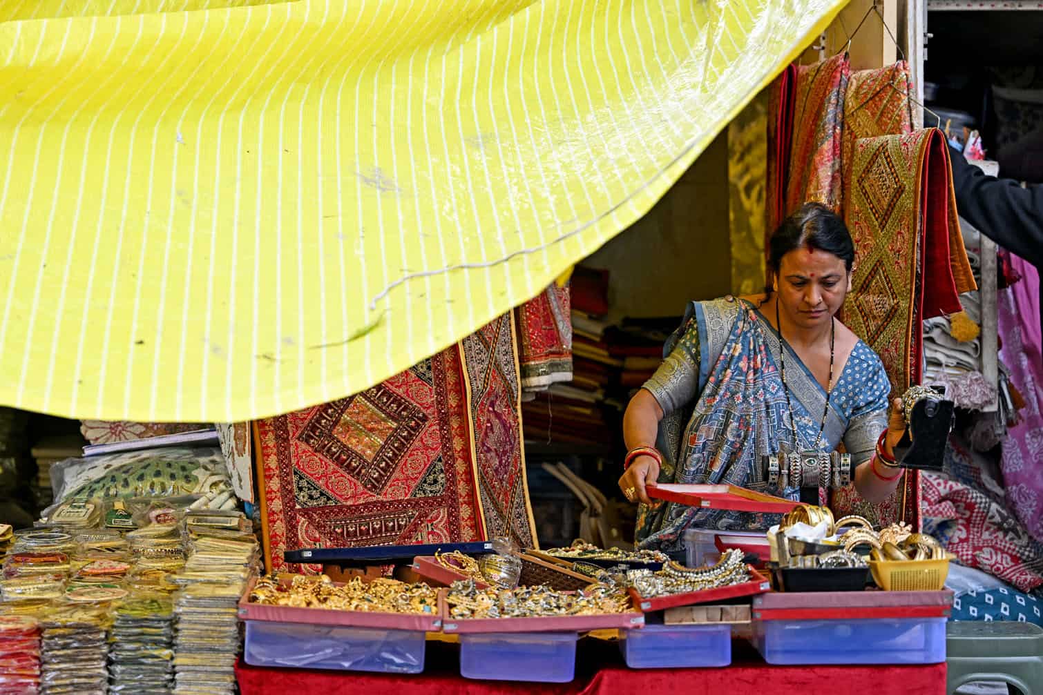 A vendor sorts ornaments at her roadside shop