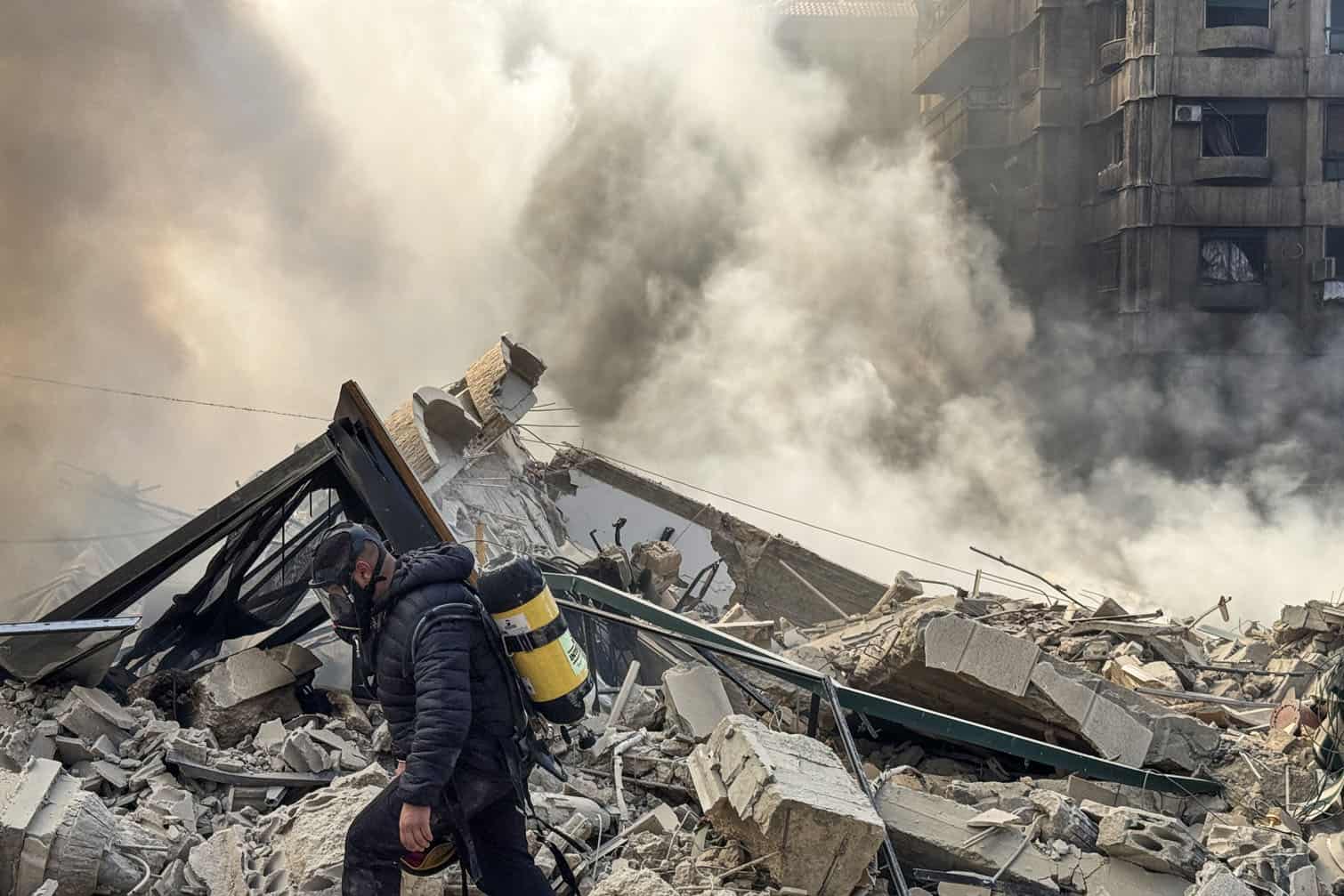 A firefighter inspects destruction at a site of an Israeli airstrike