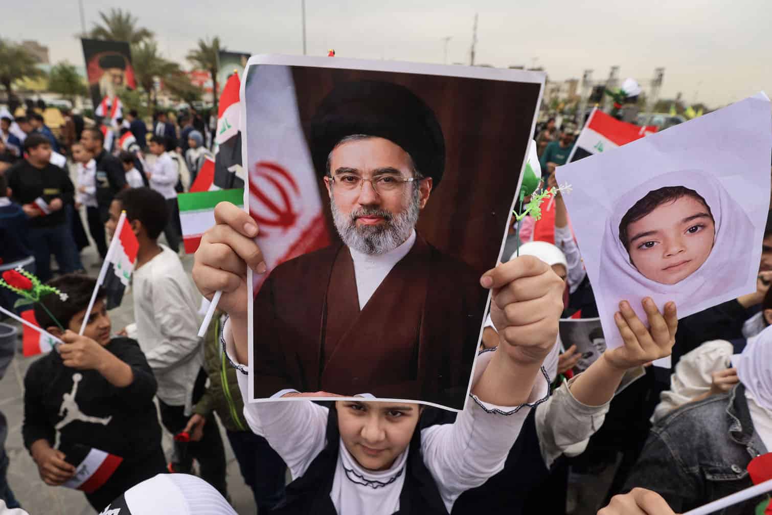 A schoolgirl holds up a poster of Iran's new supreme leader