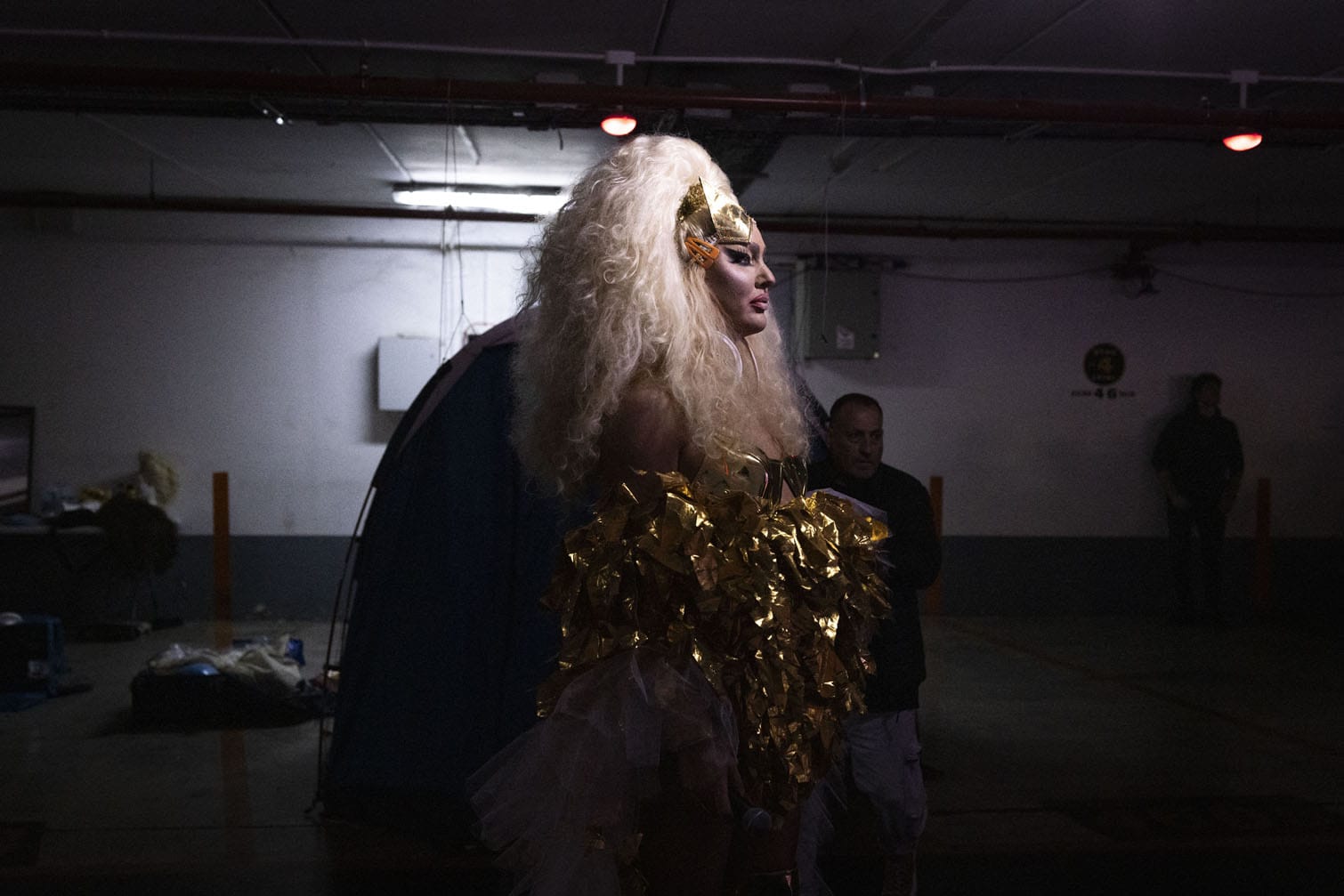 A drag queen performer looks on during a public performance