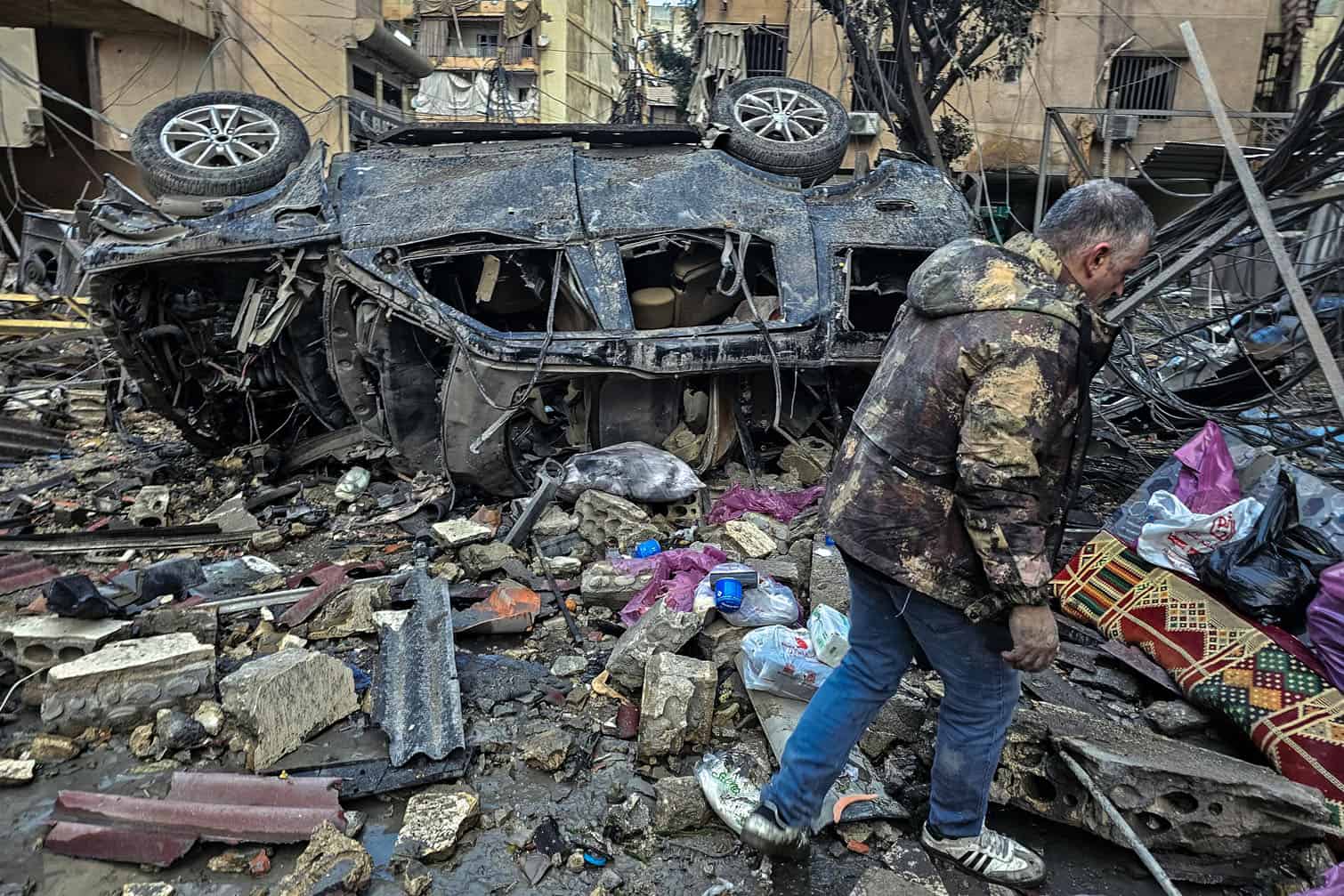 A man walks past the destruction at the site of overnight Israeli airstrikes