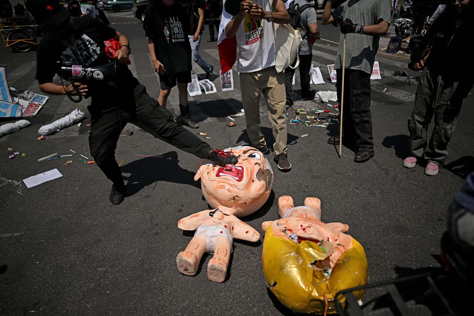 A protestor kicks a pinata