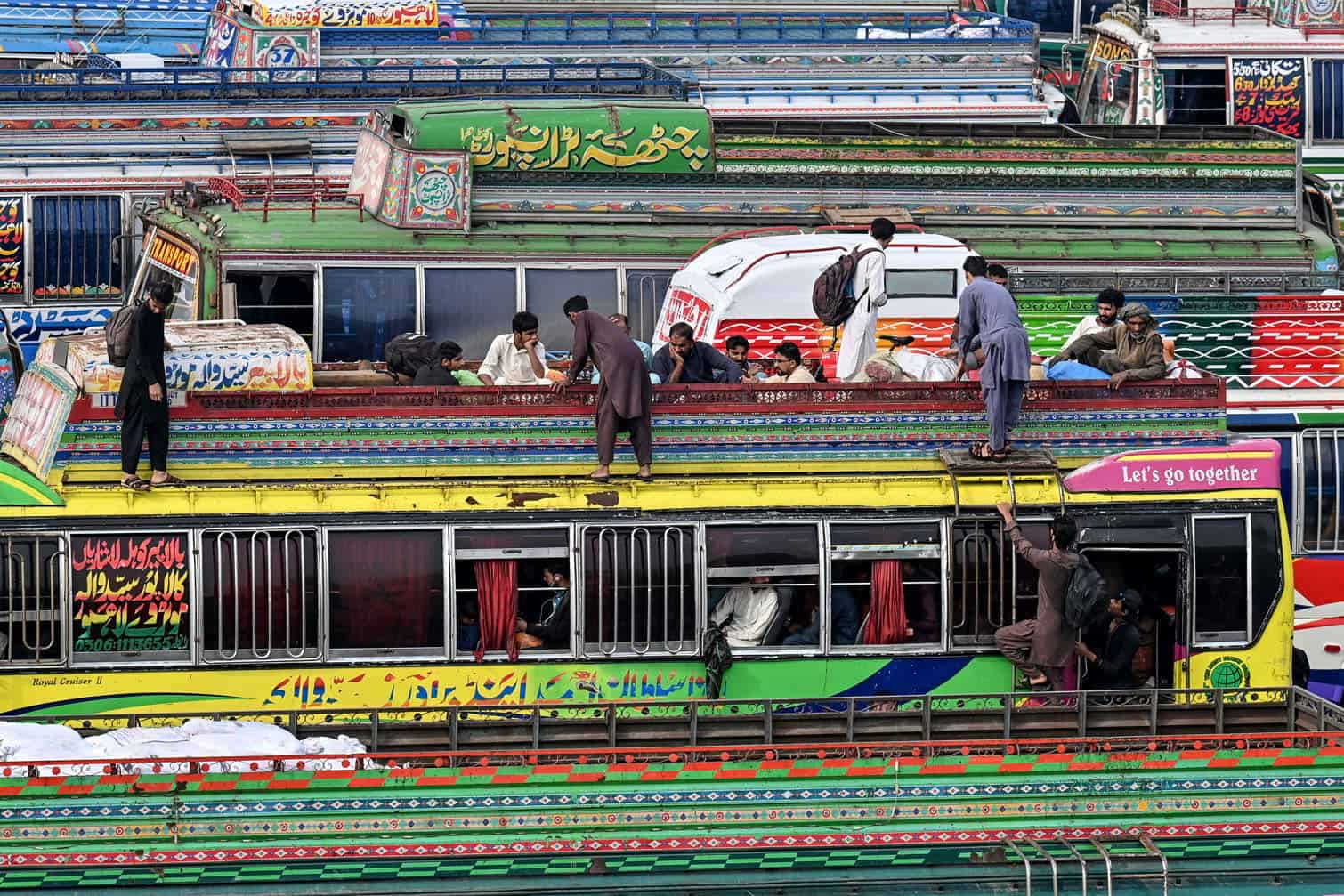 Muslims board atop a bus while returning to their hometowns