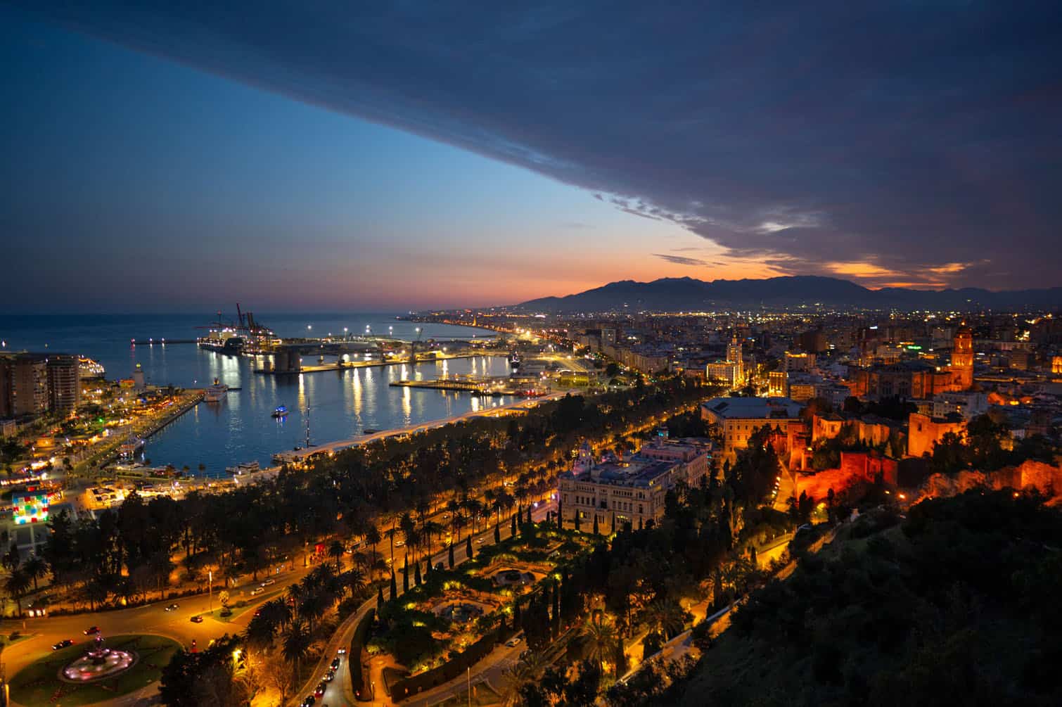 a cityscape of the southern Spanish town of Malaga at dusk